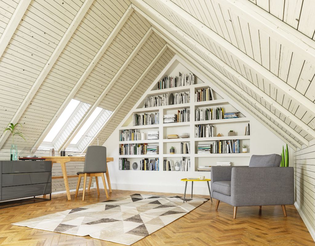 Soggiorno ristrutturato in mansarda con libreria integrata, scrivania e soffitto in legno.